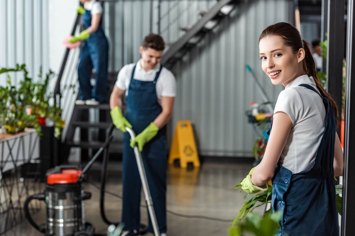 Pracownicy firmy sprzątającej dbają o porządek w nowoczesnym wnętrzu.